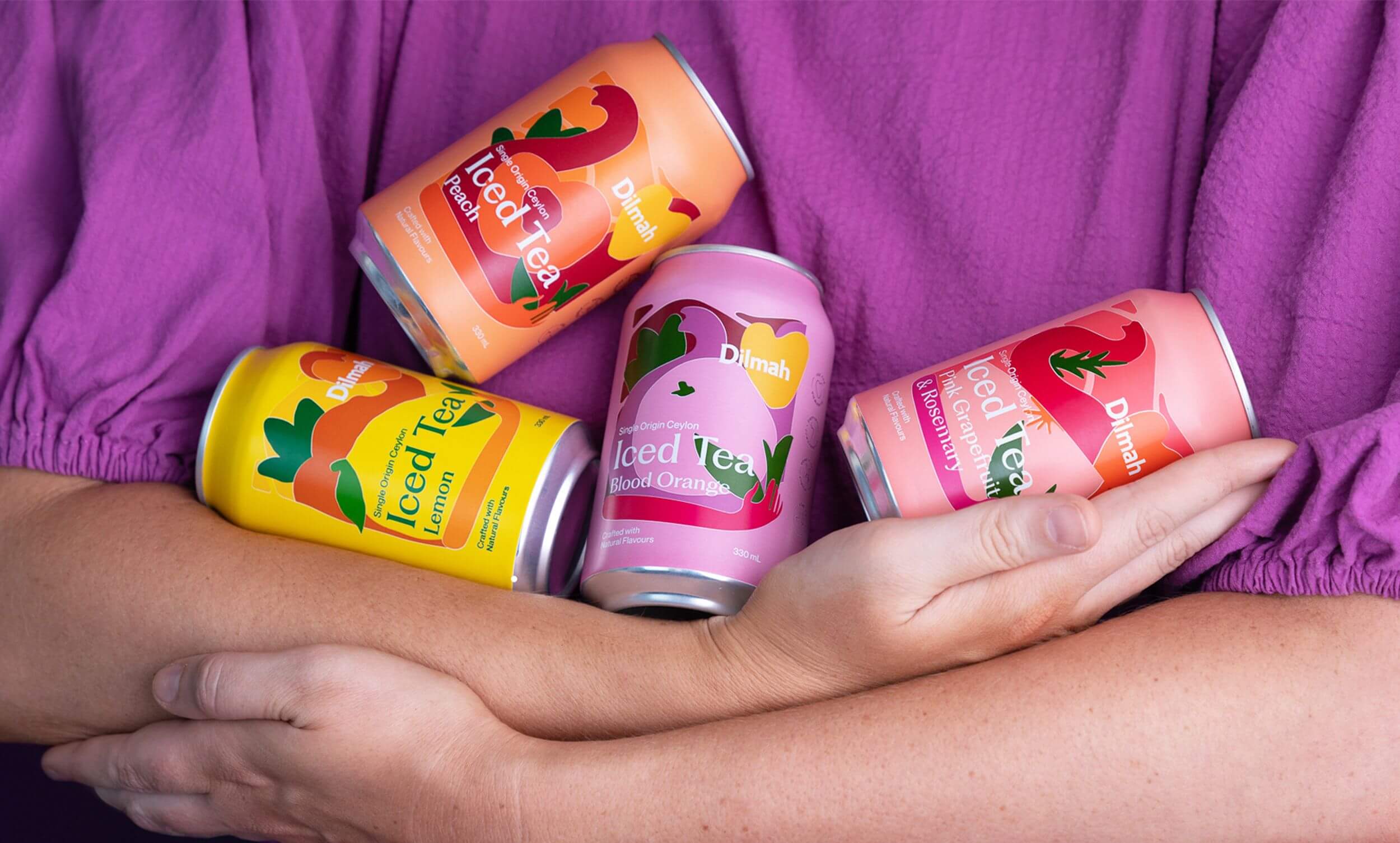 Person holding Dilmah Ice Tea cans